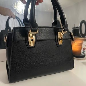 Brand New Black Purse. Comes with adjustable strap.